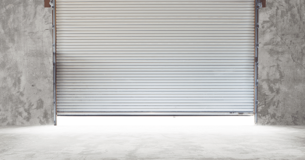 Open metal roller door in gray wall.