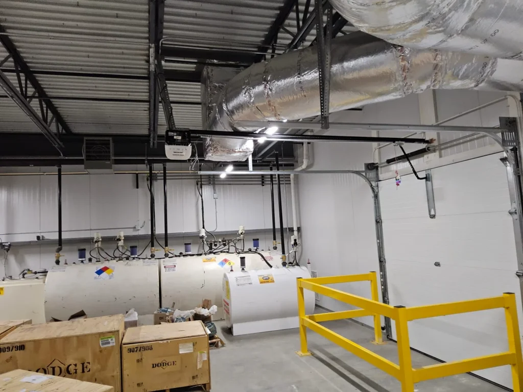 An overhead track-mounted Commercial Garage Door Opener installed in an industrial facility.