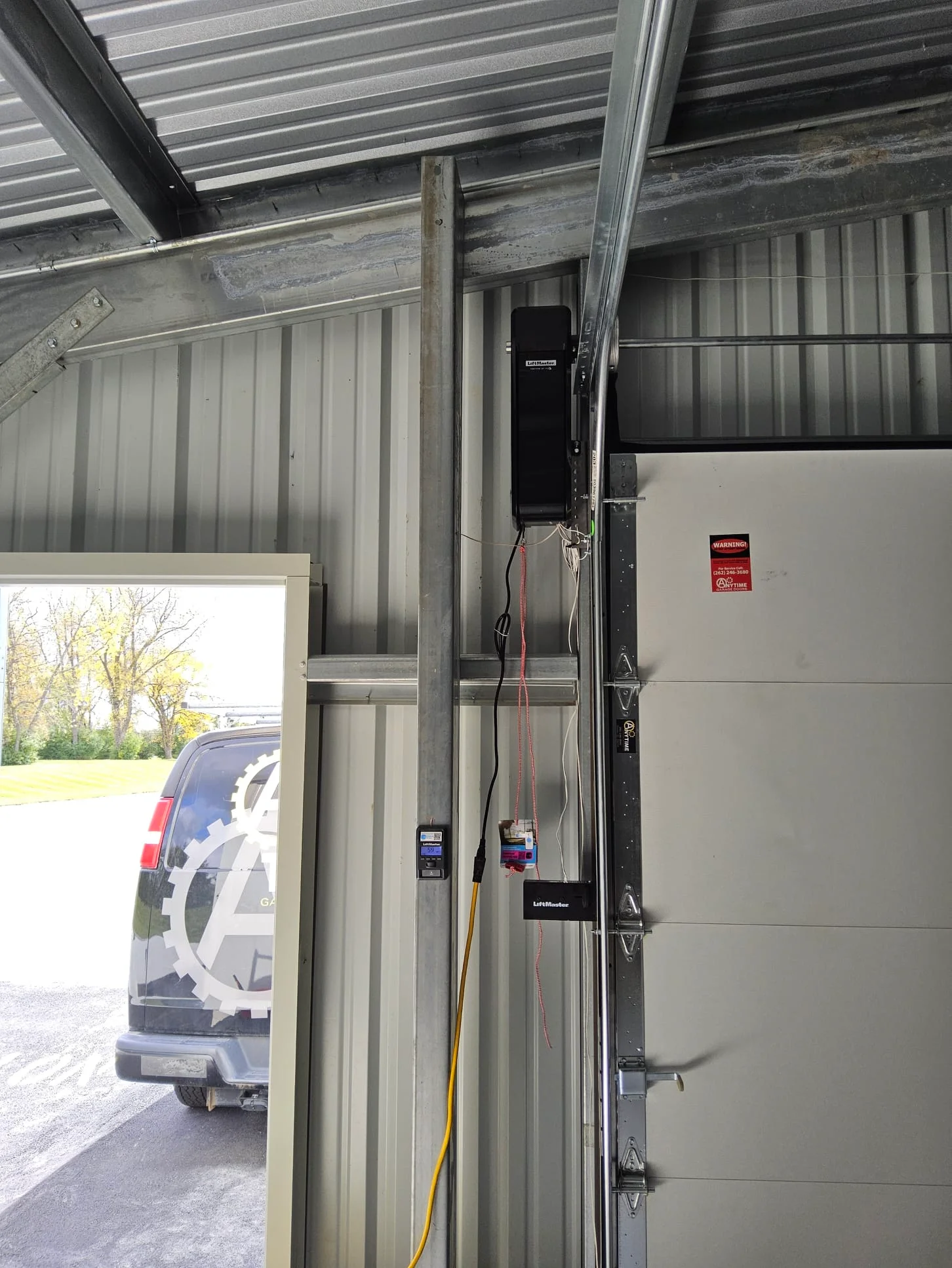 A wall-mounted side-jackshaft Garage Door Motor installed beside a commercial metal overhead door.